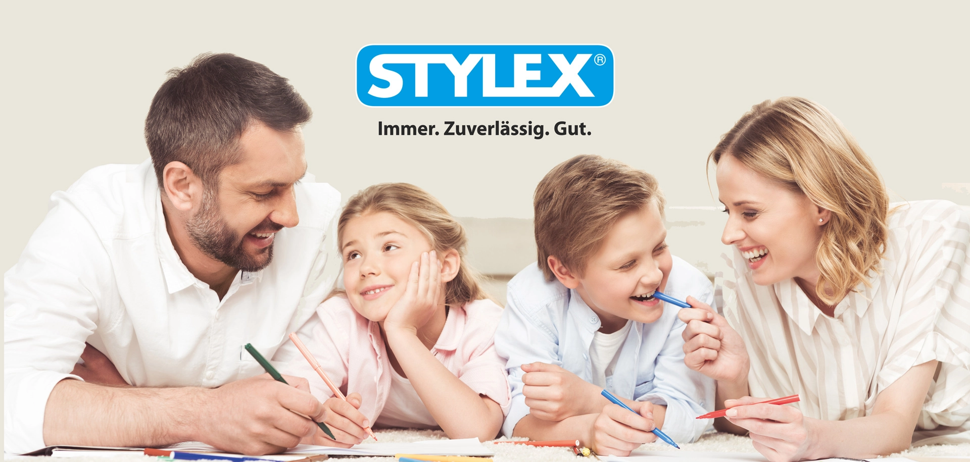 Stylex Banner Eine Familie bestehend aus Mann, Frau, Junge und Mädchen mit Stiften in der Hand und Stylex Logo über ihnen